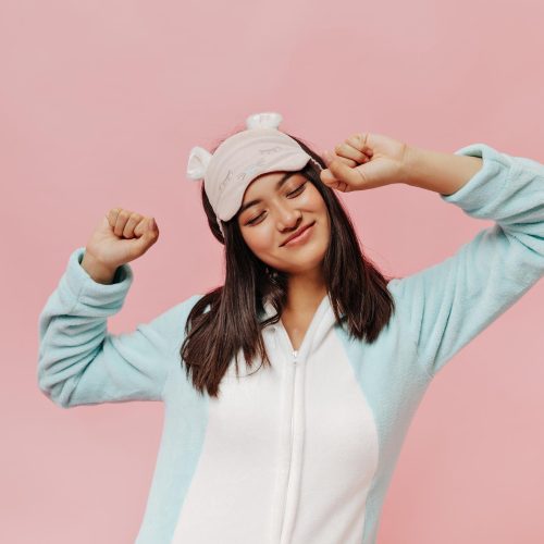 feliz-morena-mujer-asiatica-pijama-suave-antifaz-dormir-estira-sonrie-sobre-fondo-rosa-aislado feliz-morena-mujer-asiatica-pijama-suave-antifaz-dormir-estira-sonrie-sobre-fondo-rosa-aislado